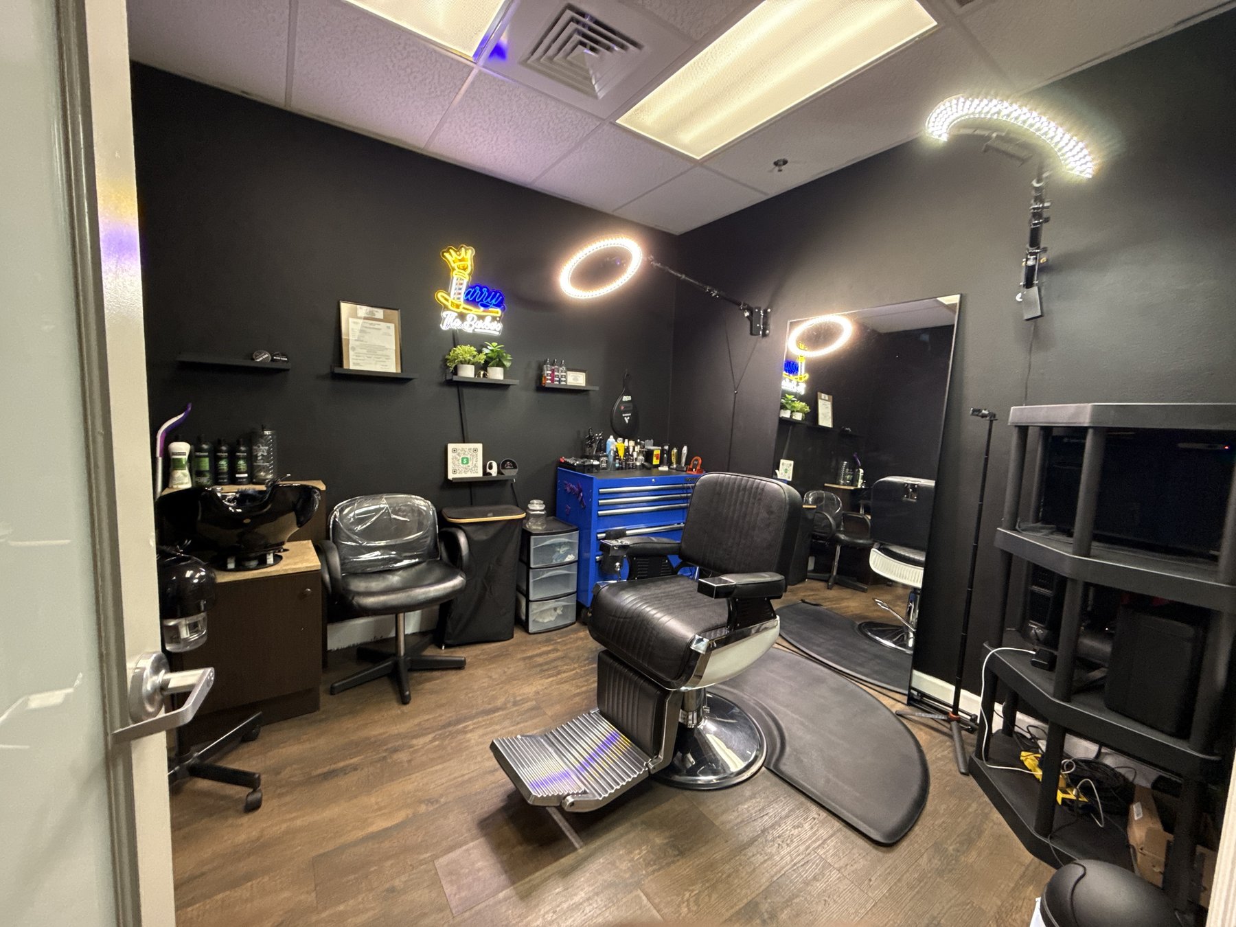 Larry The Barber shop interior with neon sign and barber chair